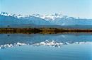 Südalpen spiegeln sich im stillen Wasser.